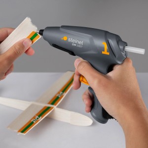 Pistolet à colle chaude Steinel GlueMatic 1007 avec bâtons de colle pour bricoler un avion en bois.