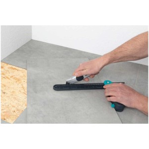 Coltello multiuso Wolfcraft in uso per tagliare rivestimenti per pavimenti.