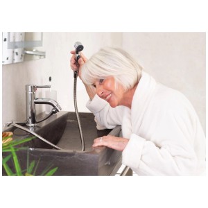 Femme utilisant le set de douche Ridder Lyon chromé au lavabo. Idéal pour un nettoyage facile dans la salle de bain et les WC.