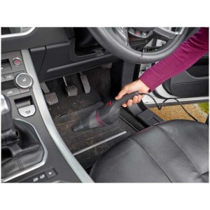 Aspirateur auto Black+Decker en cours d'utilisation pour nettoyer le plancher d'une voiture.
