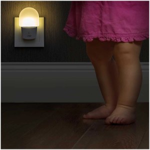 Luce notturna Reer NightGuide con sensore in uso, bambino sullo sfondo.