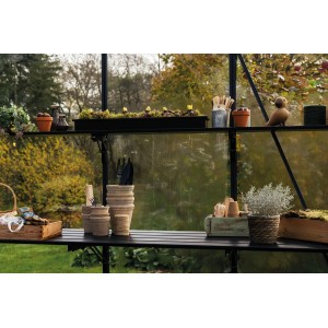 Étagère à lamelles pliante noire Juliana avec 5 sections (256 cm) dans la serre, remplie d'accessoires de jardin.