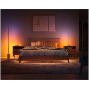 Lampe de table Philips Hue Gradient Signe Oak dans une chambre avec des couleurs dynamiques.