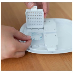 Mani inseriscono bustina di gel di silice nell'assorbitore di umidità Hombli per Smart Pet Feeder. Mantiene il cibo secco.
