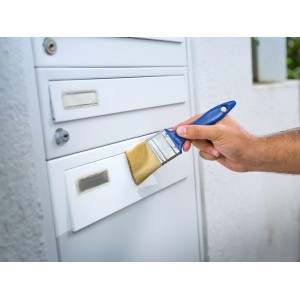 Verniciatura con pennello piatto LUX: Mano che dipinge la cassetta postale con pennello del set da 3 pezzi.