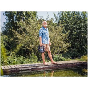Homme avec pompe submersible Gardena 9000 l pour eaux chargées près d'un bassin. Pompe électrique pour jardin.