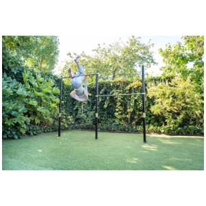 Bambino fa ginnastica sulla doppia sbarra ginnastica Exit Toys Ivy, verde e nera, in giardino. Sport & Fitness per bambini.