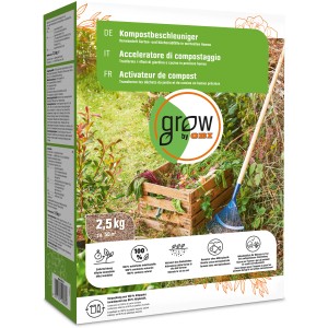 Confezione di acceleratore di compostaggio GROW by OBI da 2,5 kg davanti a cumulo di compost con scarti di giardino e rastrello.