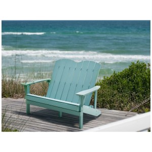 Banc de jardin Beliani Adirondack bleu clair en bois composite sur terrasse en bois face à la mer.