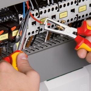Pinza spelafili Knipex (160mm) in uso per spelare un cavo in un quadro elettrico.