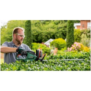 Homme taillant une haie avec le taille-haie électrique Bosch UniversalHedgeCut 50.