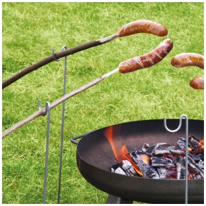 Verzinkter Grillspießhalter 70 cm mit Grillgut über Feuerstelle im Garten.