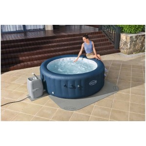 Ensemble de dalles de protection de sol Bestway LAY-Z-SPA sous un spa bleu avec une femme. 196x196cm, 17 pièces.