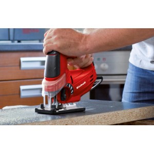 Scie sauteuse Einhell TC-JS 85 rouge en action coupant une pièce.