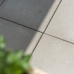 Dalles de trottoir gris ciment 30x30 cm avec chanfrein, posées pour terrasse et jardin.