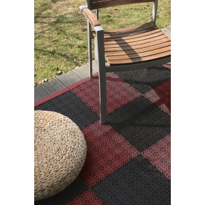 Dalles clipsables Andiamo en terracotta et noir, posées sur une terrasse avec chaise et tabouret.