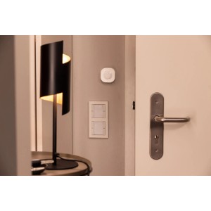 Sensore di movimento WiFi Osram Smart+ montato a parete, accanto a lampada e maniglia.