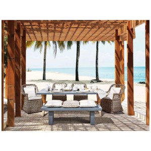 Ensemble de jardin Maros/Olbia: table béton grise, 4 fauteuils rotin avec coussins. Scène de plage méditerranéenne sous pergola.