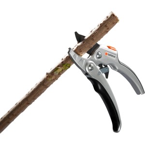 Cesoie a cricchetto Gardena Comfort SmartCut tagliano un ramo. Cesoie a incudine con funzione a cricchetto.