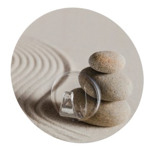 Gancio a muro Wenko Static-Loc Uno Sand and Stone davanti a sabbia e pietre.