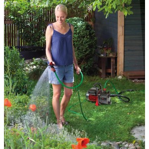 Femme arrose jardin avec pompe de jardin Einhell GC-GP 6538, tuyau inclus.