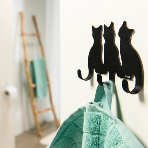 Porte-manteau Tiger noir avec trois motifs de chats dans salle de bain avec serviette.