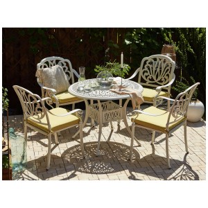 Ensemble de meubles de jardin Beliani Ancona blanc avec 4 chaises et coussins jaunes sur terrasse.