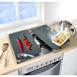 Set di 2 coperture per piano cottura Wenko Universal Cayenne su un fornello con ingredienti e utensili da cucina.