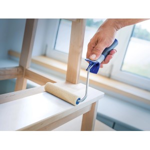 Rullo in feltro LUX (12 cm) mentre vernicia uno scaffale di legno.