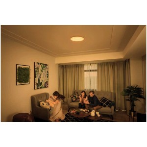 Plafonnier LED rond et lumineux Philips Izso Aio, diamètre 47 cm, dans un salon avec une famille.