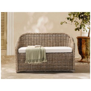 Banc de jardin en rotin naturel tressé avec coussin blanc et plaid pour 2 personnes sur une terrasse.