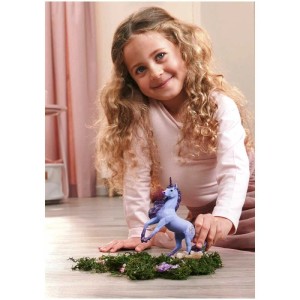 Fille jouant avec l'étalon licorne Schleich Bayala Orchid (70893) sur de la mousse.