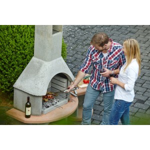 Barbecue Buschbeck Carmen avec table (gris-terracotta) utilisé pour griller dans le jardin.
