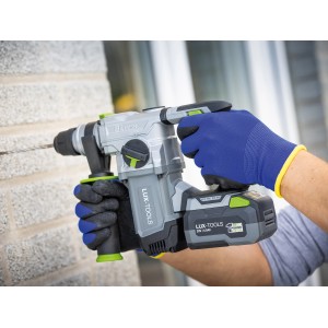 Uomo che fora con martello perforatore a batteria LUX, indossa guanti da lavoro in lattice LUX blu taglia 10.