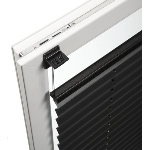 Supporto adesivo nero Gardinia Concept per tende plissettate fissato al telaio della finestra.