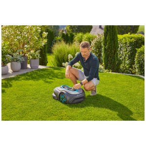 Robot tondeuse Gardena smart Sileno free 600 m² en utilisation sur pelouse, manipulé par un homme.