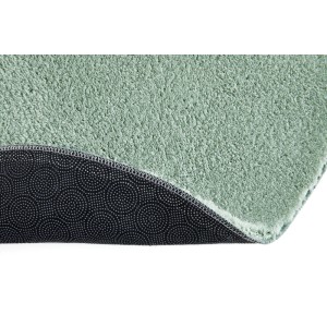 Primo piano del tappeto a pelo lungo Arezzo rotondo verde salvia, con pelo morbido e fondo antiscivolo.