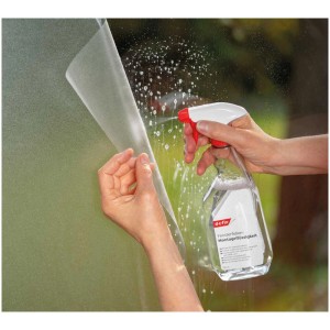 Applicazione del liquido di montaggio D-c-fix su una pellicola adesiva con un flacone spray.