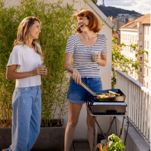 Campingaz Grill elettrico Plancha Electric 1 che griglia sul balcone con due donne.