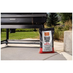 Traeger pellet di legno Apple 9 kg in sacco accanto a grill su patio. Per aroma affumicato fruttato.