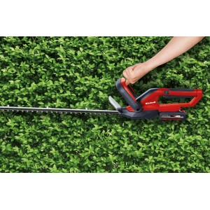Taille-haie sans fil Einhell GC-CH 1855/1 Li Kit rouge et noir taillant une haie.
