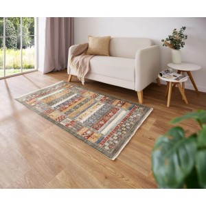 Tappeto a pelo corto Rocco (80x160 cm) multicolore con motivo etnico verde, rosso, oro su parquet in soggiorno.