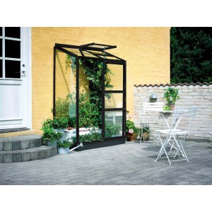 Serre noire Halls Altan 2 (0,9 m²) avec plantes contre le mur de la maison.