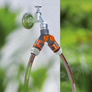 Vanne 2 voies Gardena (G 3/4") sur robinet avec deux tuyaux d'arrosage connectés.