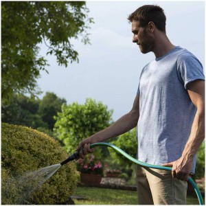 Uomo annaffia il giardino con tubo da giardino verde Fitt Idro 5/8, 50m. Irrigazione in giardino.