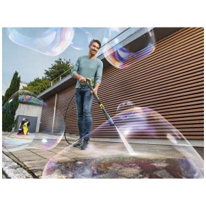 Homme nettoyant terrasse avec Kärcher Nettoyant pierres et façades 3en1. Produit de nettoyage en cours d'utilisation.