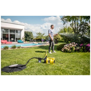 Kärcher Pompe de jardin BP 4.500 Garden en utilisation : Pompe jaune arrosant le jardin avec piscine en arrière-plan.