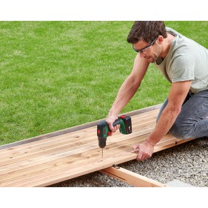Uomo che avvita una terrazza in legno con avvitatore a percussione a batteria Bosch 18V Universalimpact 18V-60 Solo.