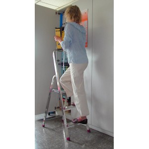 Scala a gradini Krause Corda a 3 gradini in uso: donna sale la scala per mettere i raccoglitori sullo scaffale.