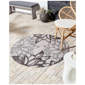 Runder Beliani Outdoor-Teppich Solapur, Ø 120 cm, mit floralem Grau-Beige Muster auf Terrasse.